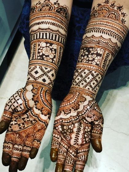 The same bold, block-style henna design, shown after the paste has dried. You can see the texture and detail in the different patterned sections.