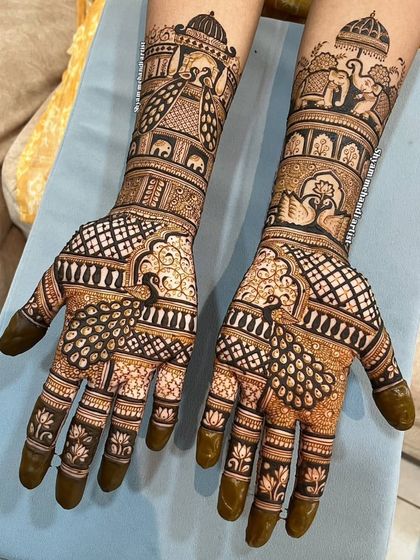 A beautiful design featuring peacocks with full plumage on the palms and elephant motifs on the arms.