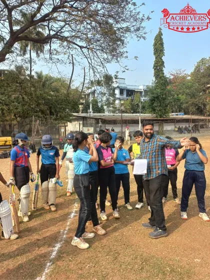 A coach addressing the group of girls who participated in the selection trials, providing feedback and encouragement.