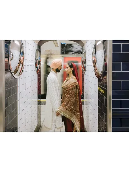 Shaan and Shubham stand in a tiled passageway in the London Underground, a train blurring past. This creative shot captures the motion and energy of the city around their still, quiet moment.