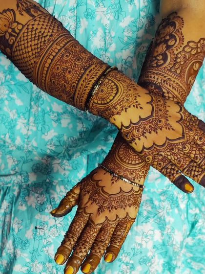 A trendy and intricate design with a focus on mandala patterns on the back of the hand and dense work on the arms.