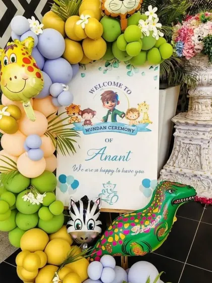 This welcome sign for Anant's mundan ceremony introduces the jungle theme with cute animal characters and a vibrant balloon arrangement.