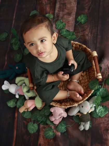 This little handsome boy is sitting in a basket surrounded by his favorite toys. A great way to personalize a toddler photoshoot.
