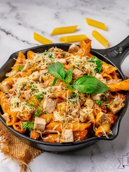 A pan of my signature pink sauce pasta, generously topped with cheese and fresh basil. This dish is a favourite at parties, combining the richness of white sauce and the tang of red sauce for a perfect balance.