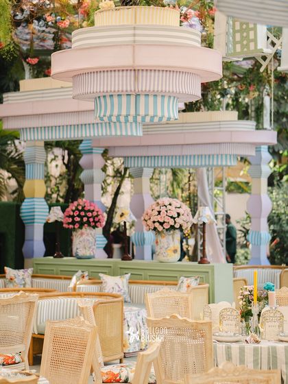 A stunning custom-built structure with pastel-colored, tiered chandeliers, creating a focal point for this garden party.