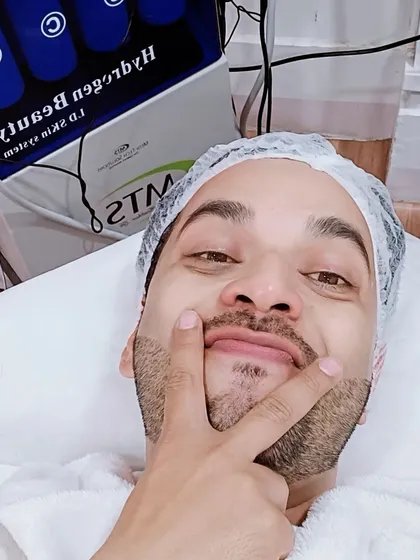 A happy client taking a selfie during his HydraFacial treatment. He is enjoying the process and getting ready for glowing skin.