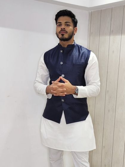 A client posing in the navy blue jacquard jacket and white kurta set, showing how it can be styled for a confident and modern look.