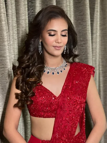 A close up on the finale look. The soft glam eye makeup and perfectly contoured cheeks complement the sparkling red saree and diamond jewelry, creating a look that is pure Hollywood glamour.