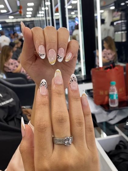 A stylish and modern design combining a French tip with a partial leopard print for a unique look.