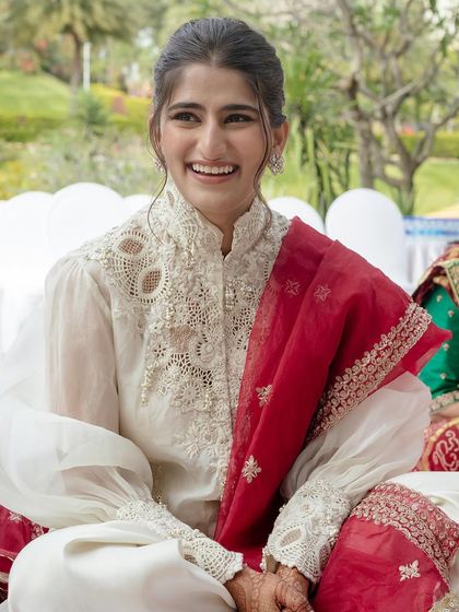 For the Ganpati Pooja, Sneha wore this elegant white Anamika Khanna outfit. We added a custom red dupatta for the ceremony, which she could later remove to greet guests.