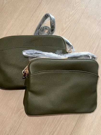 Two of the olive green Australia Crossbody bags, fresh from the supplier and still in their packaging.