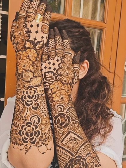 Hiding behind a wall of beautiful henna. This full-coverage floral design is perfect for the bride who wants a bold and romantic look.