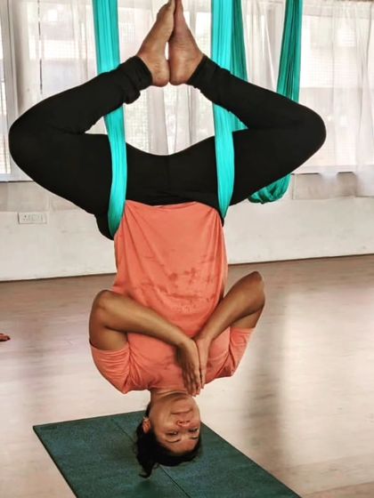 Can't keep calm when you're hanging upside down! A student enjoying a supported inversion, a key part of our aerial yoga practice for decompression and fun.