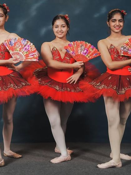 Dancers from our 'Don Quixote' performance. The use of fans as props adds a fiery, Spanish-inspired flair to the classic ballet choreography, showcasing both technique and personality.
