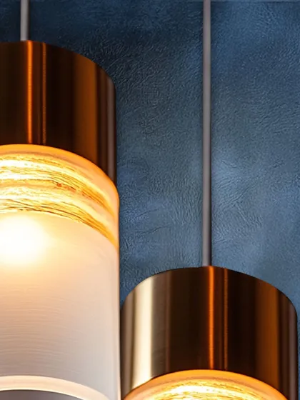 This detailed shot shows a pendant with a textured glass center and a metallic band. It’s this kind of subtle, material-focused detail that elevates a simple form into a piece of luxury design.