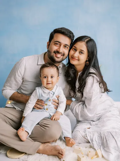 A happy family portrait against a hand-painted blue sky backdrop, created right in their home.