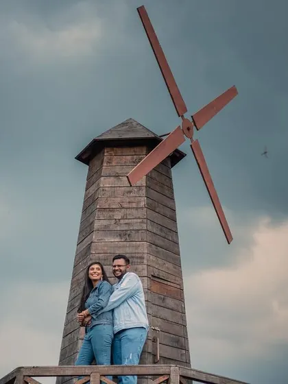 A playful and happy portrait set against a rustic windmill and a dramatic sky. This image shows how we can find beauty and create fun memories in unique, picturesque locations.