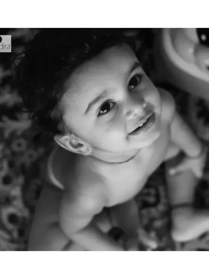 A sweet upward glance from a curious toddler during an at-home shoot. Black and white photography often highlights expression and emotion, creating a powerful and intimate portrait.