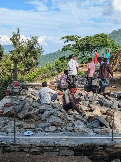 The team lays the foundation and plinth for one of the Himalayan guesthouses. This critical first step involves careful measurement and masonry to create a stable base on the uneven mountain terrain.