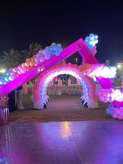A house-shaped entrance arch for a princess party, leading into a rainbow balloon tunnel for a multi-layered, enchanting welcome.