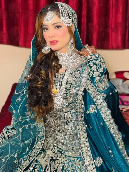 This bride is ready for her reception in a stunning teal and silver velvet gown. I created a royal look for her with silver-toned glittery eyes, contoured cheeks, and voluminous curls.