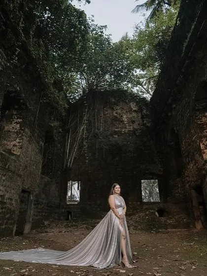 A stunning shot featuring our silver trail gown. The metallic fabric and long trail create a beautiful contrast against the historic, rustic location, perfect for a pre-wedding shoot.