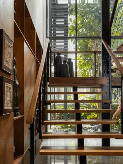 Looking up the staircase, you can see how it is framed by a large window, constantly connecting the interior with the landscape outside.
