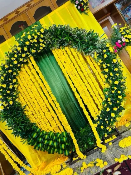 An angled shot of the Haldi decor, highlighting the three-dimensional nature of the circular arch. The layers of leaves and flowers create a very lush and full look.