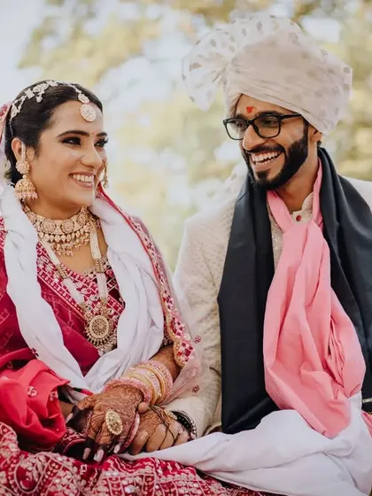 A happy, relaxed portrait of the couple seated together during their wedding, sharing a laugh.