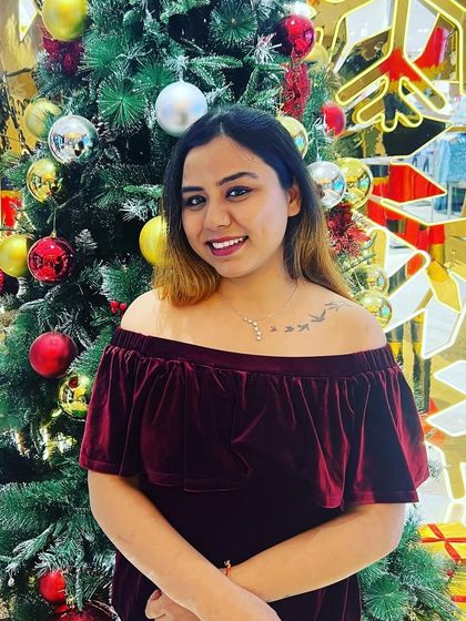 A festive portrait of me by a Christmas tree, wearing the elegant silver necklace from Giva, blending the jewelry seamlessly into a holiday look.