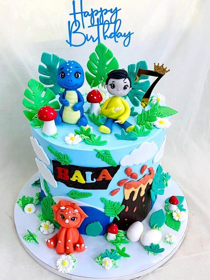 The full dinosaur cake, showing the birthday boy's figurine sitting with his dino friends.