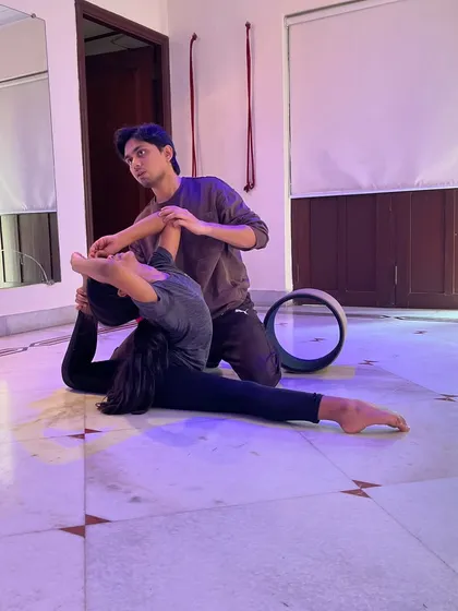 Personalised instruction is key to mastering advanced flexibility. Here, I am guiding a student through a deep backbend, using props and safe techniques to improve her form and range of motion.