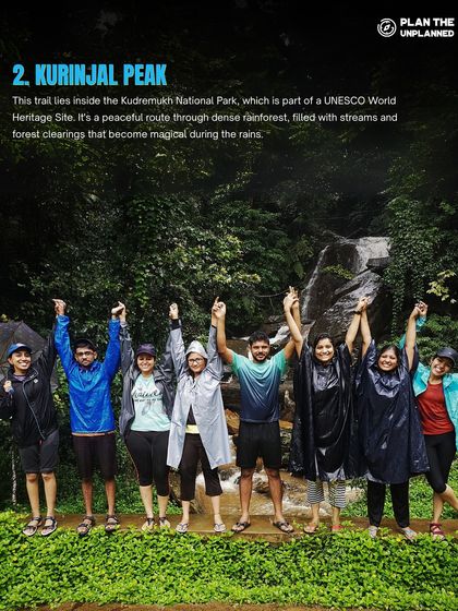 A group holds hands in celebration at a waterfall on the Kurinjal Peak trek.