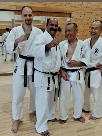 Sharing a moment of mutual respect with fellow karate practitioners after a rigorous training session in Japan.