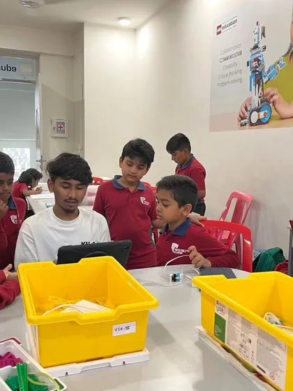 Our instructors are always ready to help. Here, a group of students from Vidyashilp Academy gets help with a programming challenge on their tablet.