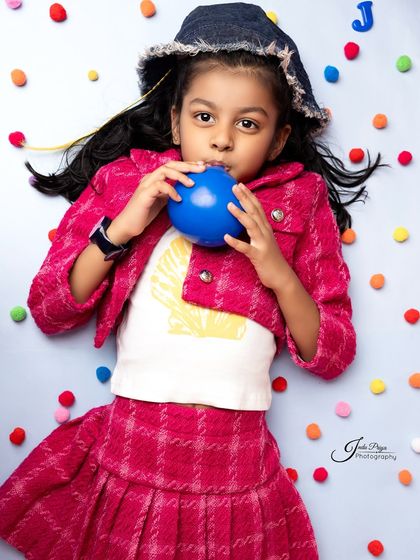 A creative overhead shot with colorful pom-poms adds texture and fun. I love experimenting with different angles and compositions to create unique portraits.