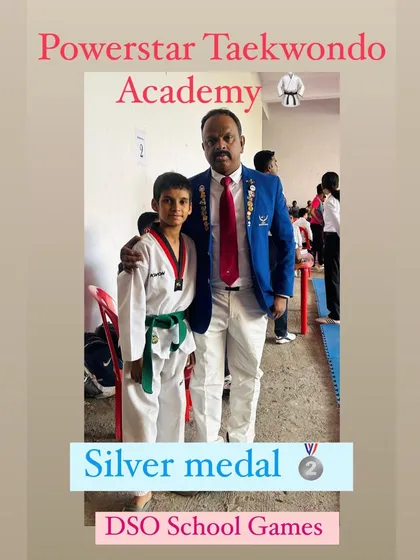 A student proudly displays his silver medal from the DSO School Games, a great achievement in his Taekwondo journey.