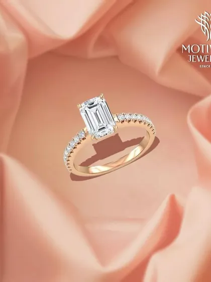 An elegant statement of love. This emerald-cut diamond is set on a delicate band paved with smaller diamonds, combining classic geometry with breathtaking sparkle.