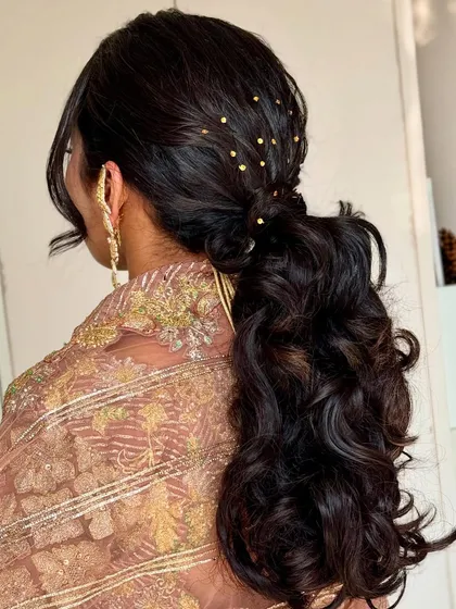 A look at the gorgeous, curly ponytail hairstyle we created for Ayushi's baby shower. The small gold details add a touch of sparkle.