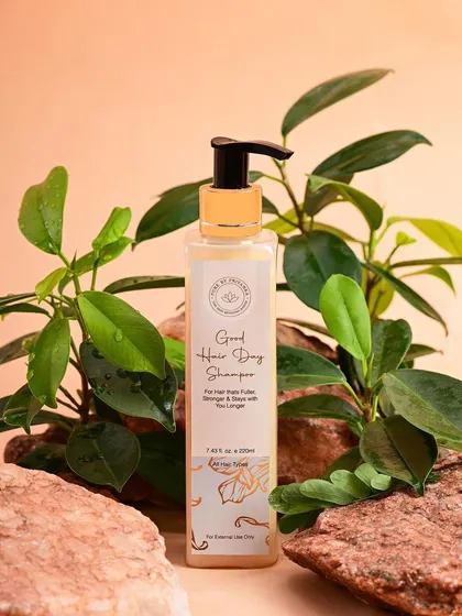 A shot of Pure by Priyanka's "Good Hair Day" shampoo, styled with natural rocks and greenery. This setup reinforces the brand's connection to natural ingredients and effective hair care.