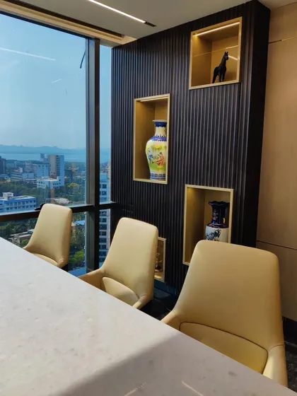 A view of the meeting area within an executive cabin, featuring display niches with gold-leaf interiors. These niches provide a curated space for art and decor, adding a personal touch to the professional environment.
