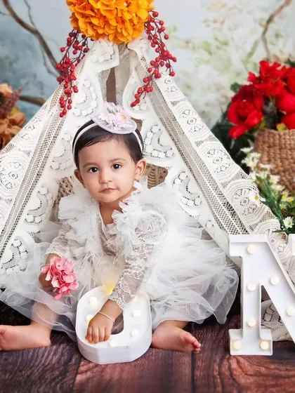 A playful moment with the light-up letters. The teepee creates a cozy little world for the baby to explore during her session.