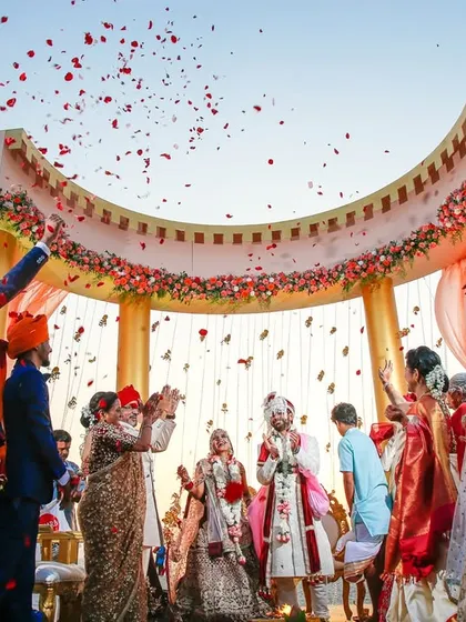 The grand Varmala ceremony, with family and friends showering the couple with blessings and petals. We focus on capturing the scale and energy of these pivotal moments, creating an image that pulls you right back into the celebration.