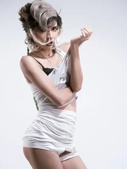 A quirky and unconventional fashion portrait. The pose and styling are intentionally awkward and playful, pushing the boundaries of a standard model test.