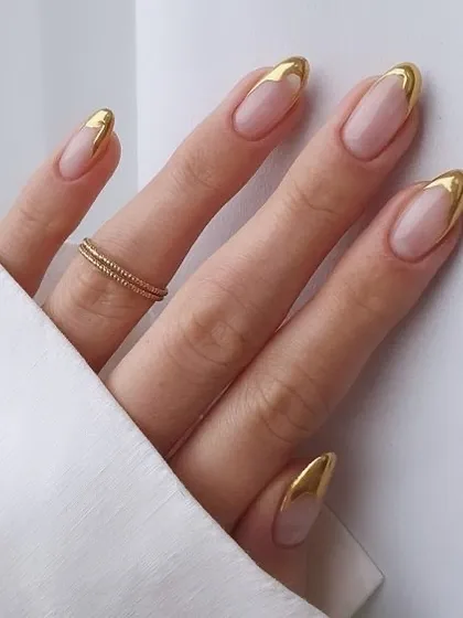 Simple, clean, and incredibly chic. This design features a classic French outline in a brilliant gold chrome on almond-shaped nails. The negative space keeps the look light and modern.