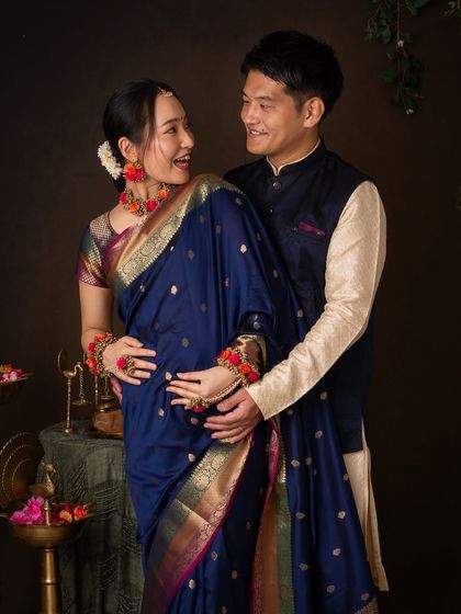 A joyful, interactive moment from our traditional Indian-themed maternity shoot. Their smiles are infectious as they celebrate their coming baby in style.