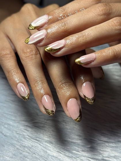 A classic nude base gets a modern upgrade with sculpted gold chrome tips. This design is elegant, edgy, and super trendy.