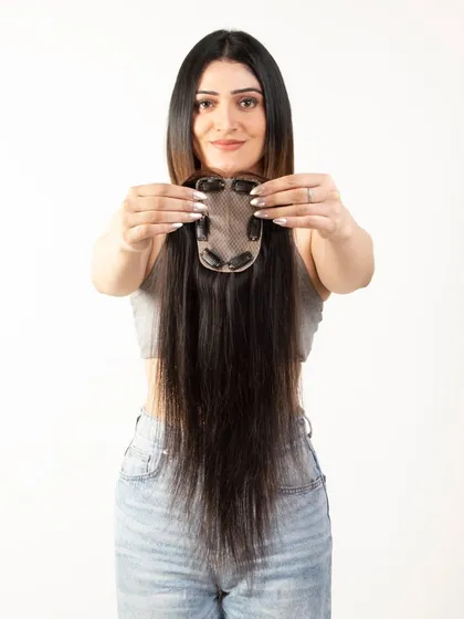 A model displaying the clip side of a long hair topper, detailing the construction for customer information.