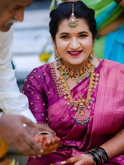 A happy bride during her wedding rituals. Her makeup is fresh and radiant, designed to last throughout the day's events.