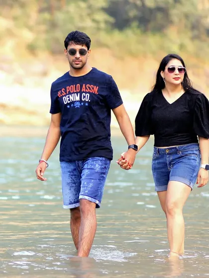 A shot from a pre-wedding session, capturing the couple walking through the water. This image has a spontaneous and adventurous feel, perfect for telling a story of love and companionship.